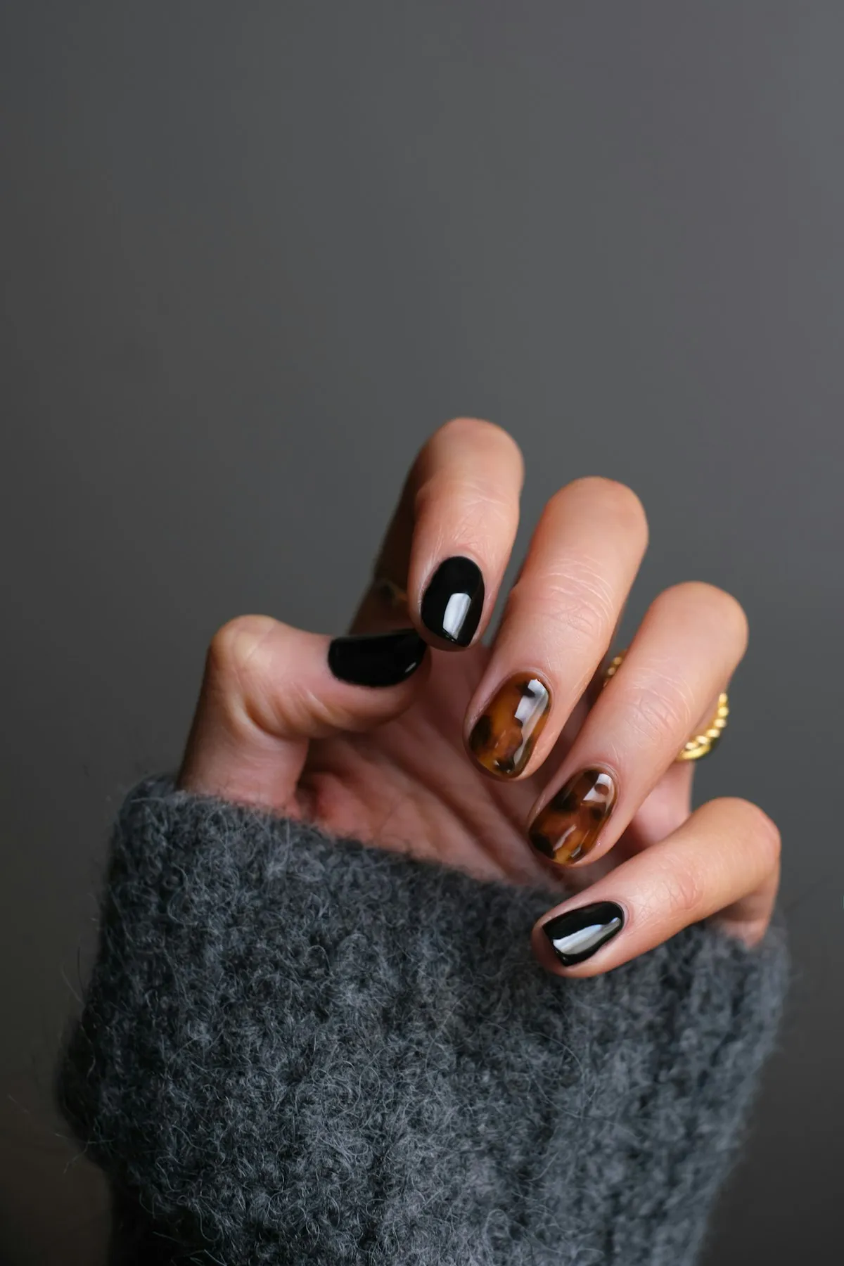Warm close-up of manicured hands with glossy nail art.